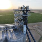 Aerial view of the Holcomb Grain Facility's 150-foot-tall concrete slip-formed structure with integrated rail loadout system, showcasing efficient grain handling operations.