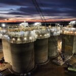 Concrete silos of the Holcomb Grain Facility under construction at dusk, featuring high-capacity storage design and integrated rail loadout systems.