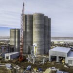 Concrete grain silos at Holcomb Grain Facility with crane, showcasing high-capacity storage and structural engineering for bulk grain handling.