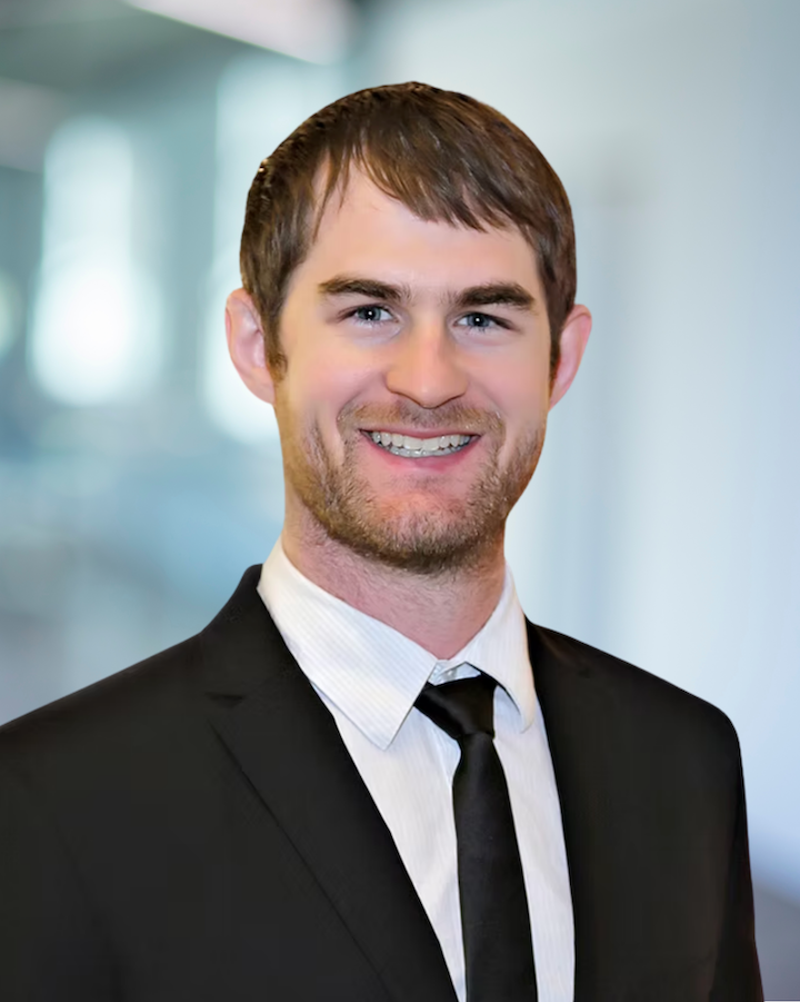 Brad Bruggeman, Design Engineer at KC Engineering, smiling in professional attire against a blurred office background.