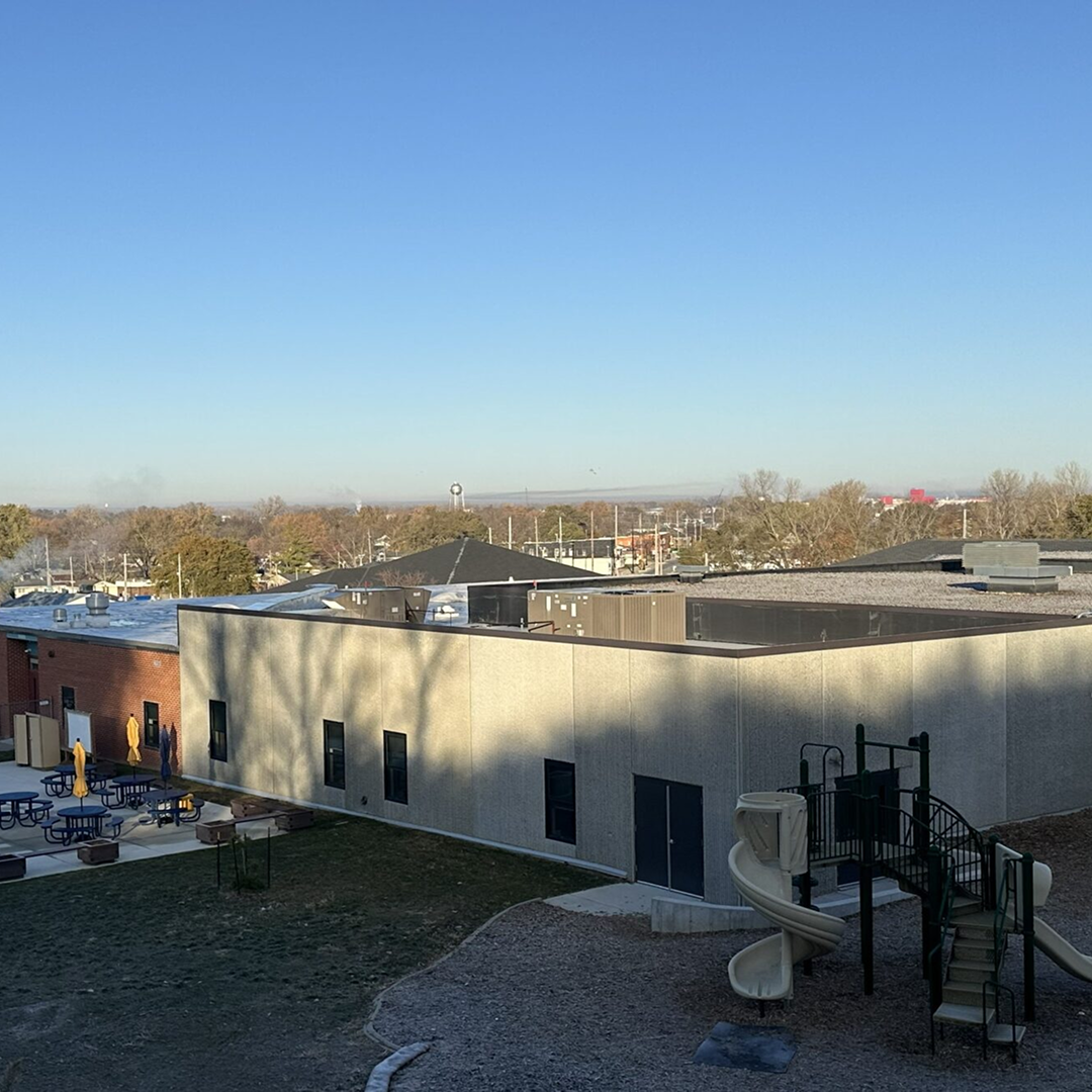 Modern facility exterior with playground equipment, emphasizing community access and functional design in architectural projects.