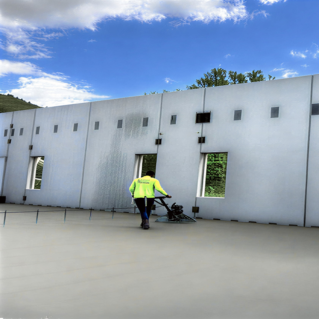 Worker operating a trowel machine on a concrete floor inside a partially constructed building, showcasing architectural progress and construction efficiency.
