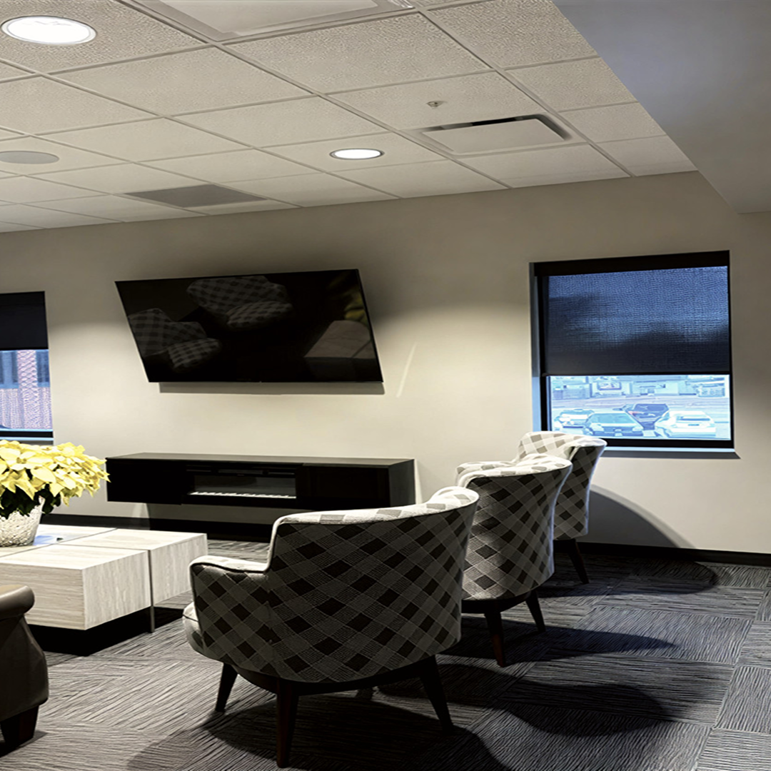 Modern waiting area with patterned chairs, wall-mounted TV, and natural light from windows, reflecting KC Engineering's focus on practical and aesthetically pleasing architectural design.