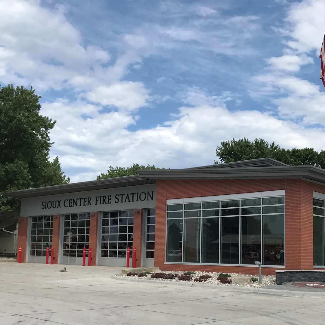 Sioux Center Fire Station exterior featuring modern architecture, large windows, and red accent details, emphasizing practical design and community service.