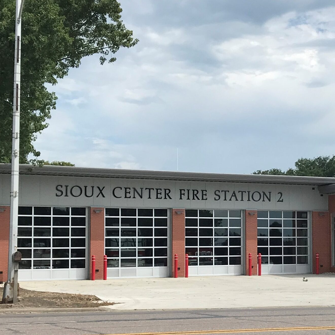 Sioux Center Fire Station 2 exterior with large glass doors and red fire hydrants, showcasing modern architectural design relevant to community safety and infrastructure.